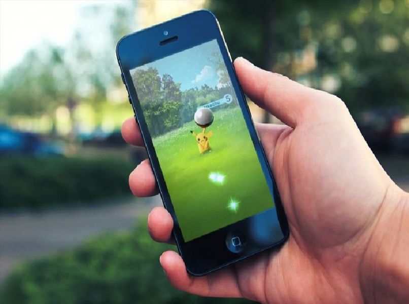 telefono android en mano con juego pokemon go