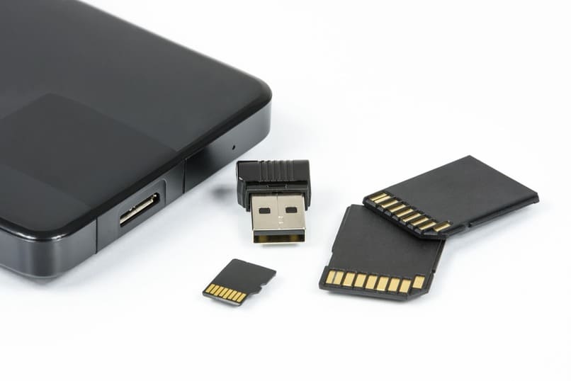 tarjetas de memoria y un usb sobre una superficie color blanco