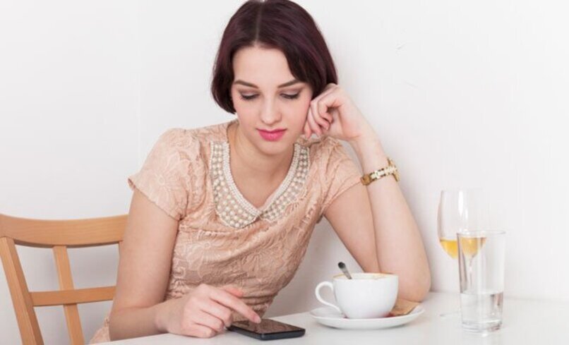 mujer revisando su dispositivo movil