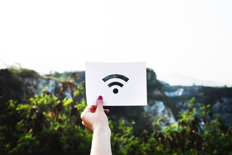 mujer sosteniendo el icono de la senal de wifi