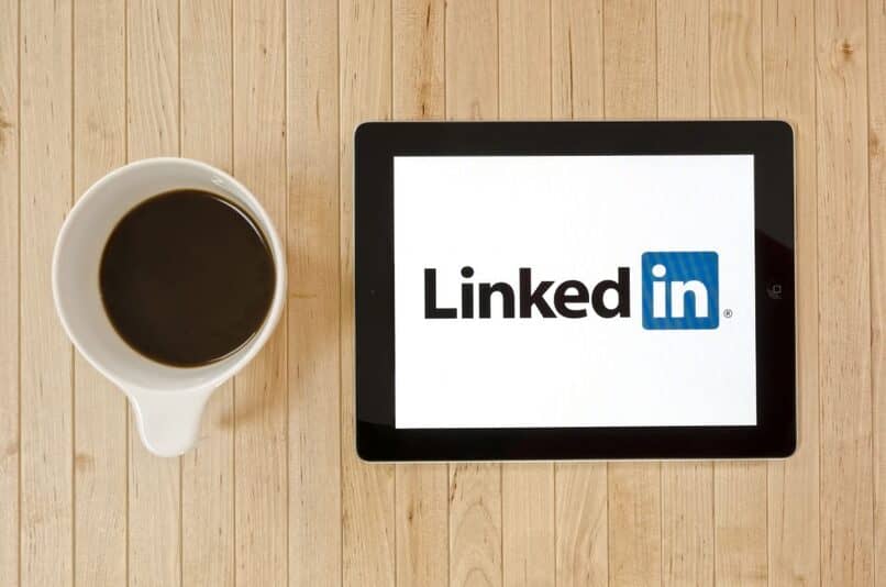 linkedin en tablet con taza de cafe al lado