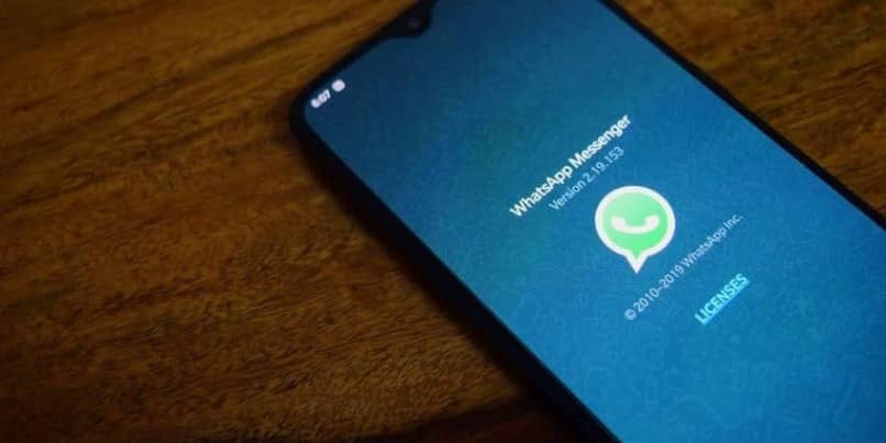 movil con pantalla inicial de whatsapp sobre mesa