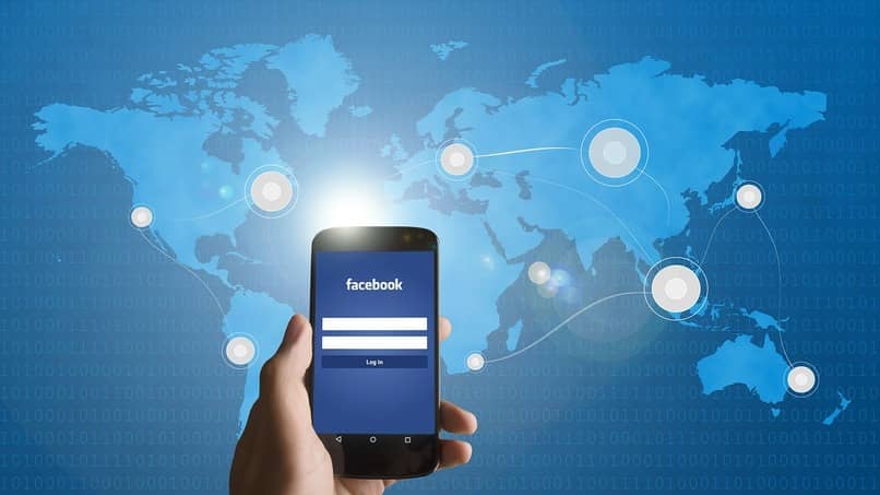 dispositivo movil utilizando facebook con mapa del mundo de fondo