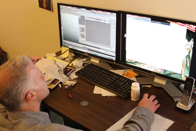 hombre utilizando dos ordenadores