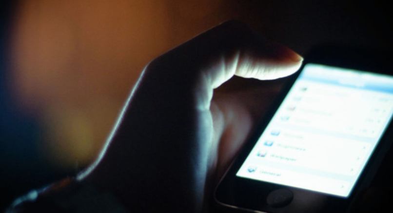 persona espiando celular iphone negro